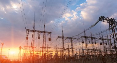 Gün batımında ya da gün doğumunda yüksek voltajlı elektrik hatları. Yüksek voltajlı elektrik iletim kulesi.