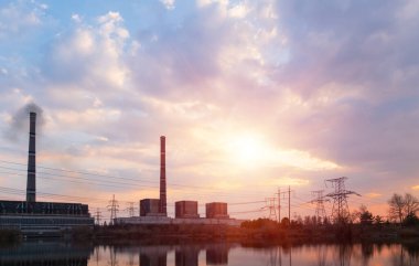 Elektrik hatları ve trafolar olan elektrik santralini gün batımında dağıtın.