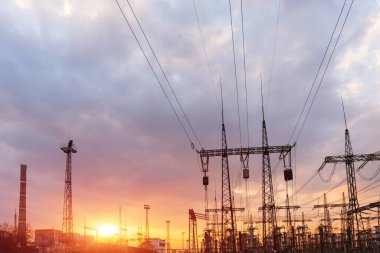 Akşamki elektrik iletim kulesinin silueti. Bir enerji santralinden bir şehre güç aktarımı