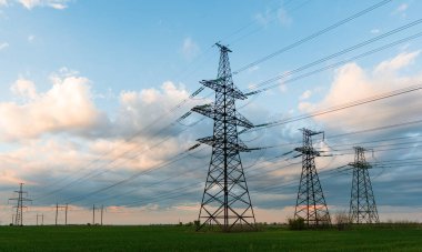 Güzel bir günbatımında elektrik hatları. Dünyanın güzel manzaralarında elektrik taşımacılığı.