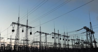 Elektrik hatları ve trafolar olan elektrik santralini gün batımında dağıtın.