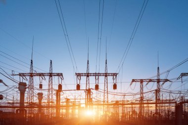 Elektrik hatları ve trafolar olan elektrik santralini gün batımında dağıtın.