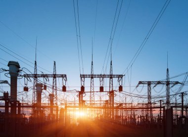 Elektrik hatları ve trafolar olan elektrik santralini gün batımında dağıtın.