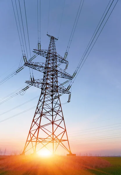 Gün batımında ya da gün doğumunda yüksek voltajlı elektrik hatları. Yüksek voltajlı elektrik iletim kulesi.