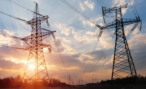 Günbatımında yüksek voltajlı elektrik hatları. Elektrik dağıtım istasyonu. yüksek voltajlı elektrik iletim kulesi