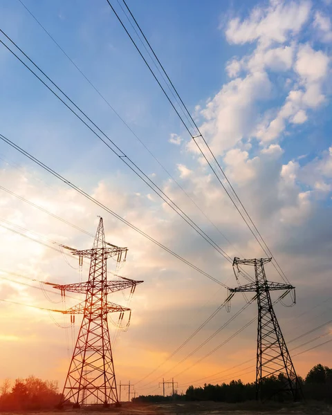 Gün batımında ya da gün doğumunda yüksek voltajlı elektrik hatları. Yüksek voltajlı elektrik iletim kulesi.