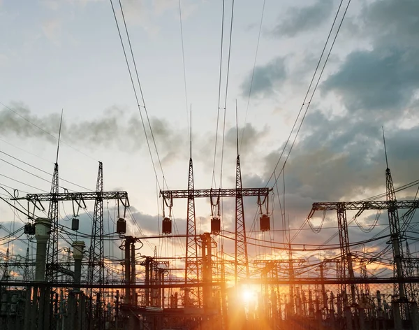 The silhouette of the evening electricity transmission pylon. Power transmission from a power plant to a city