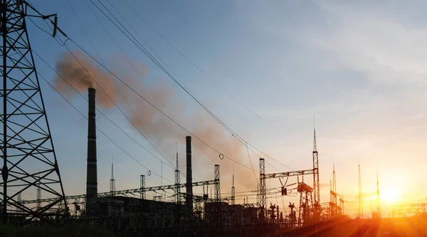 The silhouette of the evening electricity transmission pylon. Power transmission from a power plant to a city