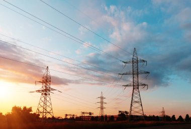 Elektrik hatları ve trafolar olan elektrik santralini gün batımında dağıtın.