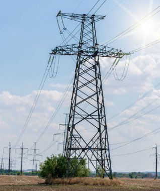 Akşamki elektrik iletim kulesinin silueti. Bir enerji santralinden bir şehre güç aktarımı