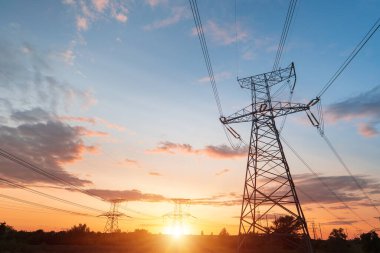 Siluet Yüksek voltajlı elektrik kulesi gün batımı saatinde ve gökyüzü günbatımı arkaplanında