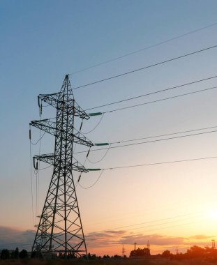Akşamki elektrik iletim kulesinin silueti. Bir enerji santralinden bir şehre güç aktarımı