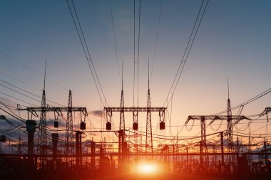 Elektrik hatları ve trafolar olan elektrik santralini gün batımında dağıtın.