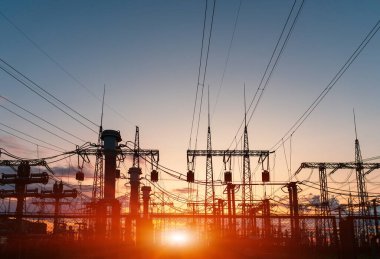 Yüksek voltajlı elektrik hatları. Elektrik dağıtım istasyonu. Yüksek voltajlı elektrik iletim kulesi. Güç hatları ve trafoları olan dağıtım elektrik santrali.