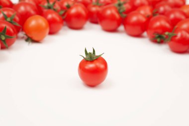 Beyaz arka planda dağınık kırmızı domatesler. Küçük ve sulu sebzeler vitamin ve eser elementler açısından zengindir. Sağlıklı yiyecekler. Taze ve organik sebzeler. Çiğ yemek..