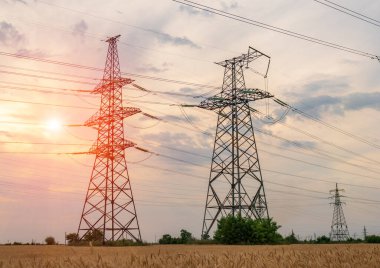 Kentsel alanda yüksek elektrik direkleri var. Enerji arzı, enerji dağılımı, enerji iletimi, enerji iletimi, yüksek voltaj arzı konsepti fotoğrafı.