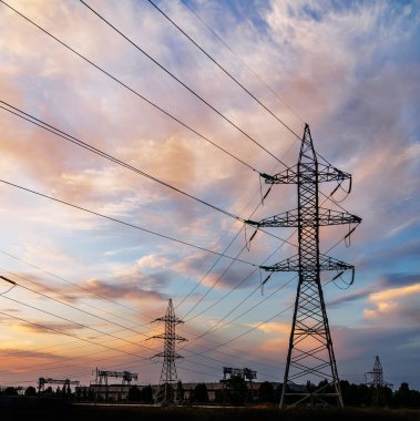 Yüksek voltajlı elektrik hatları. Elektrik dağıtım istasyonu. Yüksek voltajlı elektrik iletim kulesi. Güç hatları ve trafoları olan dağıtım elektrik santrali.