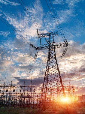 Yüksek voltajlı elektrik hatları. Elektrik dağıtım istasyonu. Yüksek voltajlı elektrik iletim kulesi. Güç hatları ve trafoları olan dağıtım elektrik santrali.
