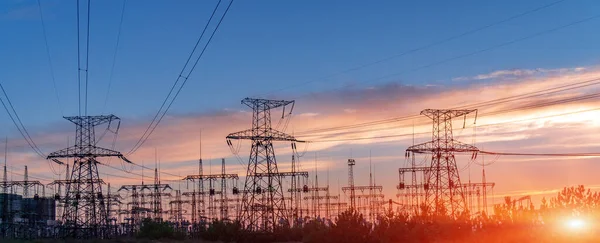 Elektrik hatları ve trafolar olan elektrik santralini gün batımında dağıtın.