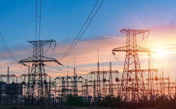 distribution electric substation with power lines and transformers, at sunset