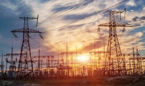 distribution electric substation with power lines and transformers, at sunset