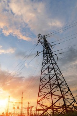 Gün batımında ya da gün doğumunda yüksek voltajlı elektrik hatları. Yüksek voltajlı elektrik iletim kulesi.