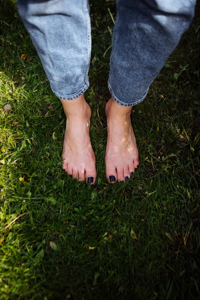feet of a woman in a green grass