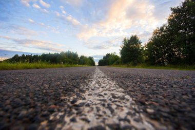 Yol çizgisi. Asfalt yolu ve yaz manzarası gün batımında.