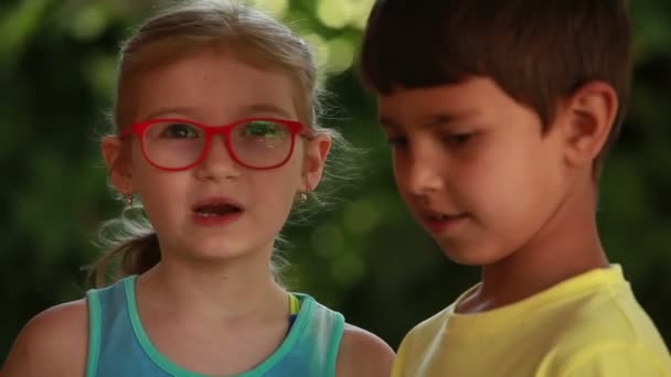 Мальчик и девочка разных национальностей разговаривают — стоковое видео