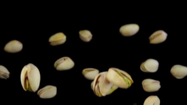 Les pistaches volent gros plan, sur un fond noir — Video