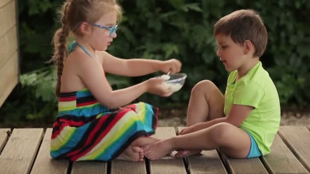 少年お粥をスプーンで餌をやる少女 — ストック動画