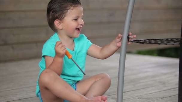 Kleine jongen spelen met een schroevendraaier — Stockvideo