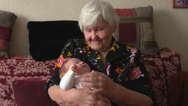 Mormor håller å en sondotter — Stockvideo