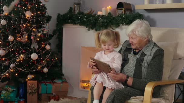 Baby spelen op de tablet zittend op de schoot — Stockvideo