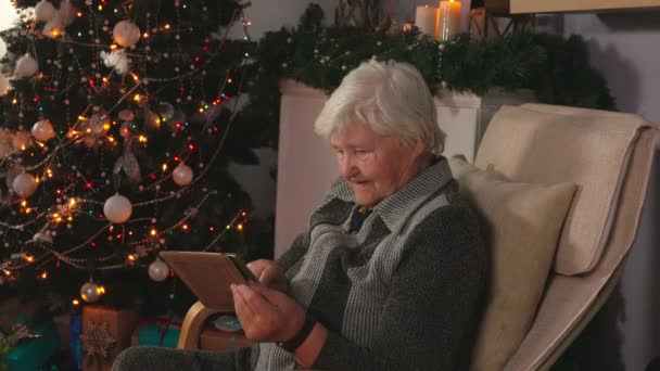 Starsza kobieta czyta wiadomość na tablecie — Wideo stockowe