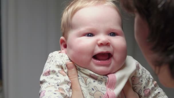 Bonito menino de olhos azuis sorrindo para os braços das mães — Vídeo de Stock