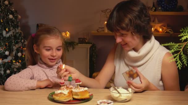 Moeder en dochter licht Kerst kaarsen — Stockvideo