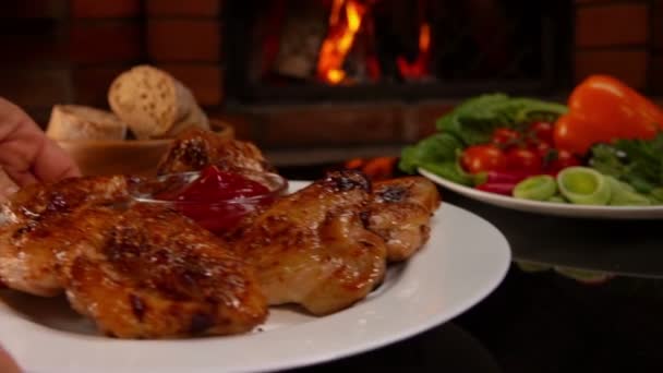 Pon a mano sobre la mesa un plato de alitas de pollo frito — Vídeos de Stock