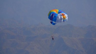 Denizin üzerinde özel bir paraşüt üzerinde uçan adam