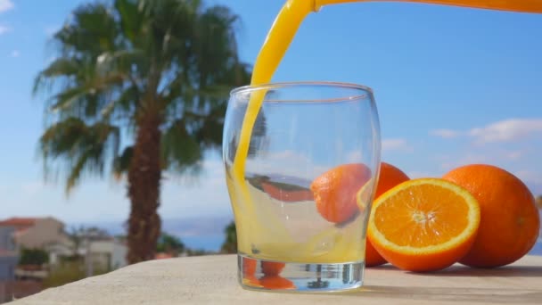 Крупним планом апельсиновий сік вливають у склянку — стокове відео
