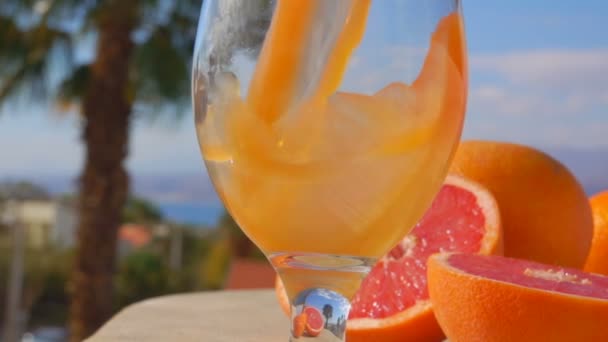 Grapefruitsap wordt gegoten in een wijn-glas — Stockvideo