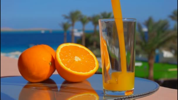 Orangensaft in ein Glas gegossen — Stockvideo