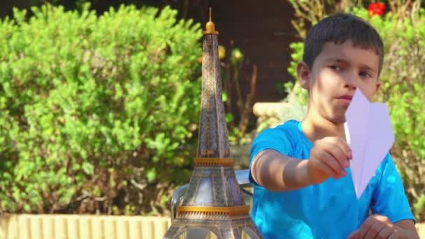 Niño jugando con un avión de papel — Vídeo de stock