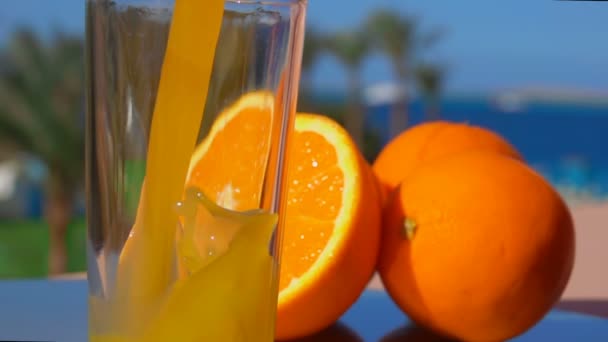 Close-up suco de laranja derramado em um copo — Vídeo de Stock