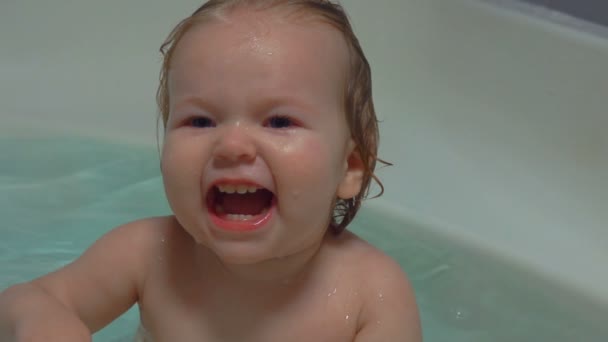 Happy baby lachen in het water in de badkamer — Stockvideo