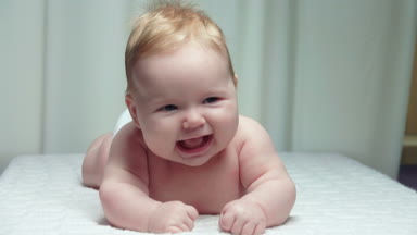 Midesi üzerinde büyüleyici mavi gözlü bebek yalan.