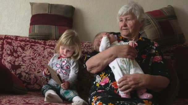 Geat-abuela se sienta con sus nietas — Vídeo de stock