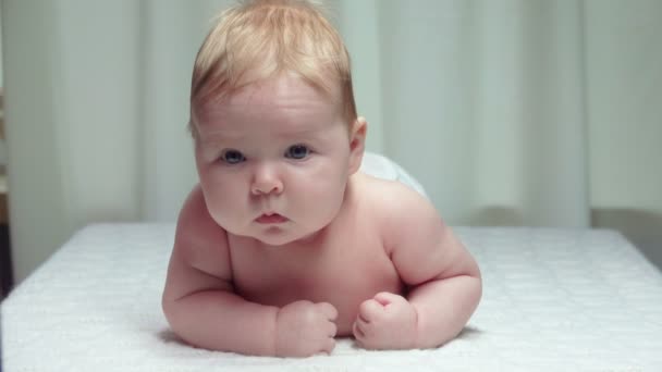 Pequeno bebê feliz jaz em seu estômago — Vídeo de Stock