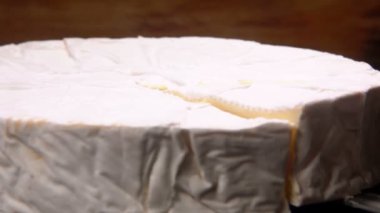 Bıçak yuvarlak brie peyniri bir bölümünü kaldırdı. Kamera Pan hareketi