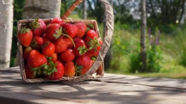 Sepet ve ahşap bir masa ile olgun çilek düştü
